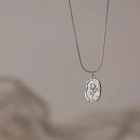 Stainless steel embossed tulip coin pendant necklace on flat snake chain in gold