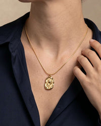 Embossed tulip coin pendant necklace on flat snake chain in gold