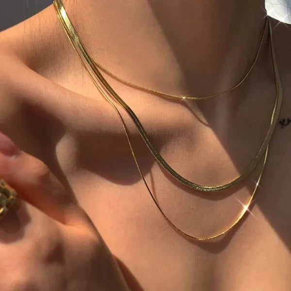 Flat herringbone snake chain necklace in stainless steel with gold and silver finishes, available in multiple widths and lengths