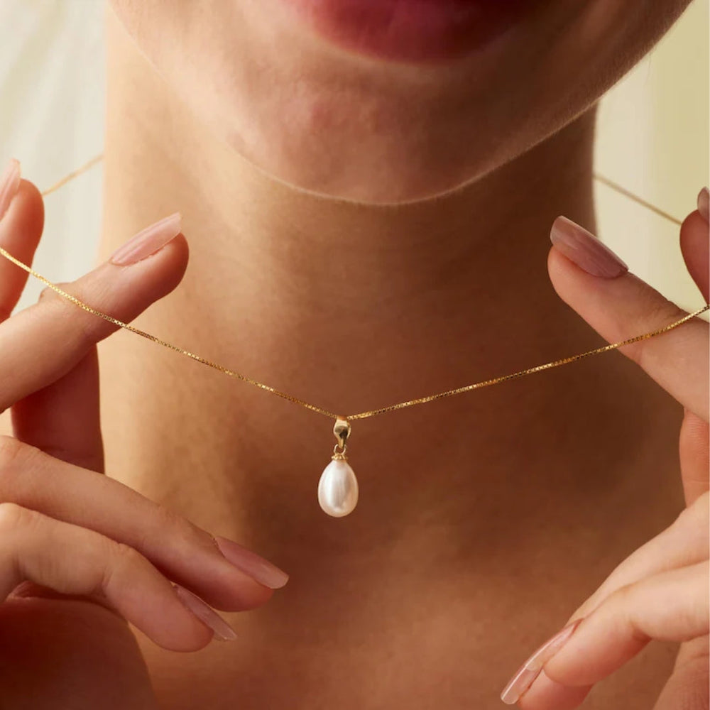 Delicate freshwater pearl drop pendant necklace on a gold chain at collarbone length