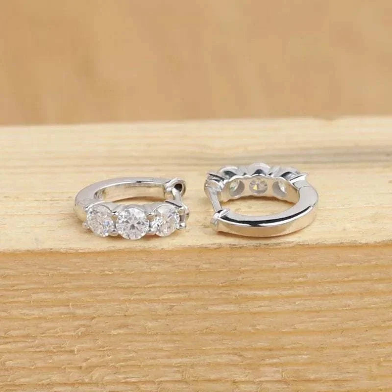 Close-up of 925 sterling silver moissanite hoop earrings with round D/VVS1 stones, showcasing luxury sparkle and classic design