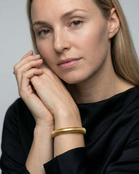 Multi-strand stacked bangle set in mixed gold and silver tones on wrist