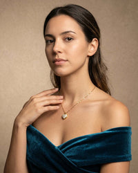 gold heart pendant necklace with a pearl center on a chain