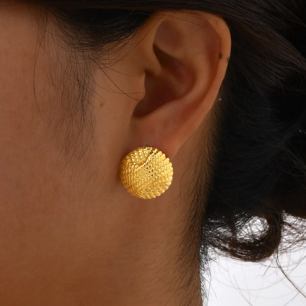 Close-up of textured dome stud earrings with 18K gold plating and round chunky design