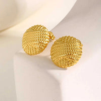 Close-up of textured dome stud earrings with 18K gold plating on stainless steel, showcasing chunky round design and woven surface.