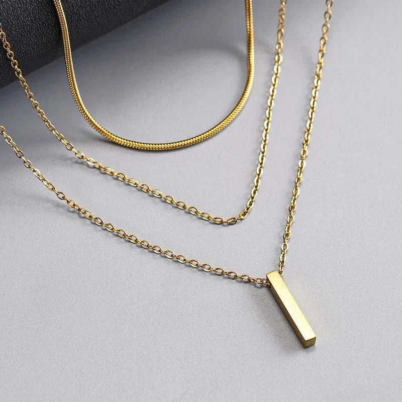 gold triple layer bar pendant necklace on white background