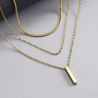gold triple layer bar pendant necklace on white background