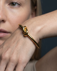 18K gold plated twisted knot cuff bangle with open round design on wrist