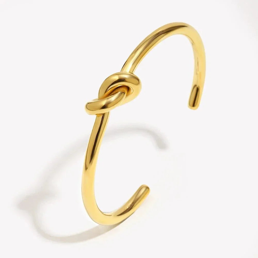 18K gold plated twisted knot cuff bangle on wrist with minimalist open cuff design