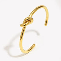 18K gold plated twisted knot cuff bangle on wrist with minimalist open cuff design