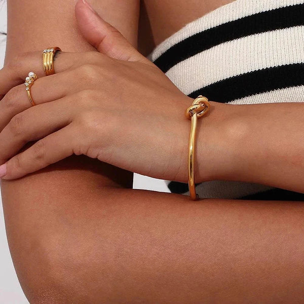 18K gold plated twisted knot cuff bangle in minimalist open design on wrist
